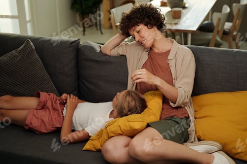 Preview: Youthful serene girl lying on pillow on her mother knees and having chat