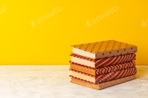Preview: Stacked books on wooden desk front view