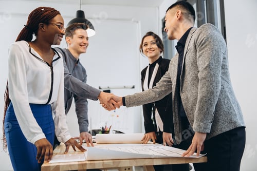 Preview: Diverse businessmen shaking hands after signing contracts at group multiracial meeting
