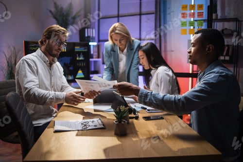 Preview: Multiracial economists having meeting late in office