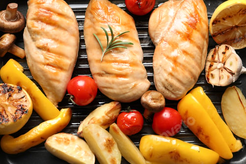 Vista previa: Fried chicken breasts and garnish in grill pan as background