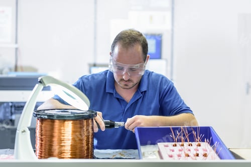 Preview: Male worker assembling electromagnetic coils in electronics factory