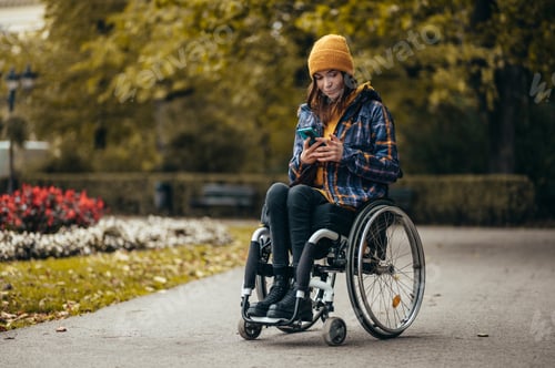 Preview: Woman with disability using a smartphone while out in the city park