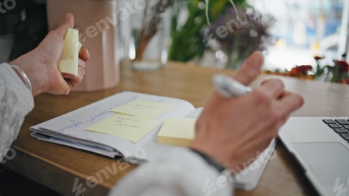 Preview: Businesswoman hands write notes stickers on desk. Close up lady create ideas.