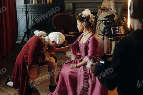 Preview: Caucasian Young Adult Man Kneeling and Kissing Hand of Caucasian Woman
