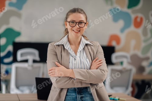 Preview: Confident businesswoman smiling with crossed arms in modern office