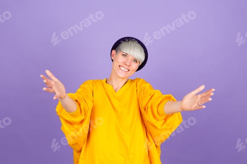 Preview: Stylish european woman on purple background looking at the camera smiling with open arms for hug