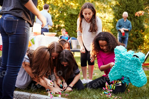 Preview: Young girls collecting sweets from a broken pi–ata