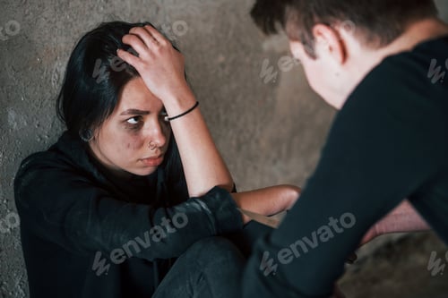 Preview: Kidnapped woman sitting and threatened by man with knife in hands in abandoned building