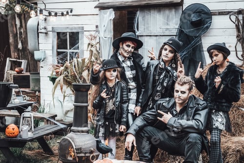 Preview: Scary family, mother, father, daughters celebrating halloween. Terrifying black skull half-face make