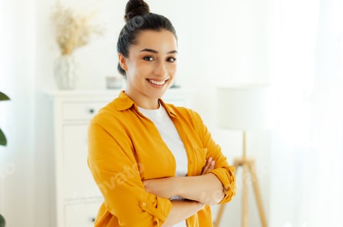 Preview: Portrait of a gorgeous arabian or indian ethnicity young woman dressed in orange shirt, company
