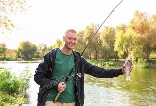Preview: Man with rod fishing at riverside on sunny day. Recreational activity