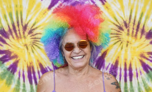 Preview: Old woman wearing colorful wig and hippie sunglasses smiling on camera