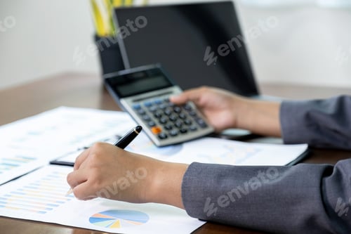 Preview: Businesswomen hand use calculator analysis the graph for Setting challenging business goals
