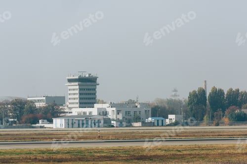 Preview: Runway on airfield with airport buildings at background