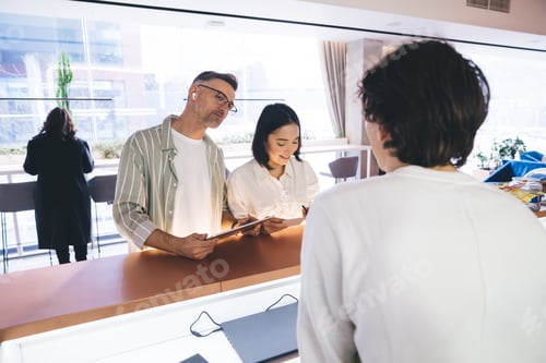 Preview: Diverse husband and wife during check in at reception