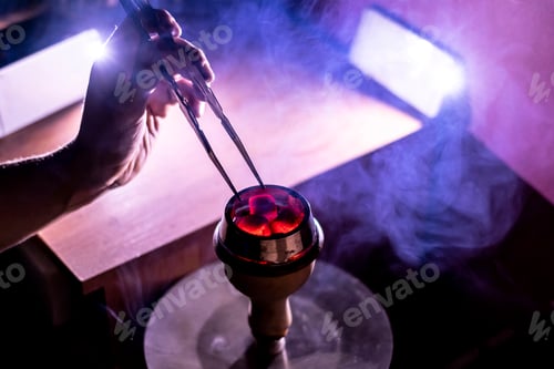 Preview: person hold red glowing coal for hookah and blow it