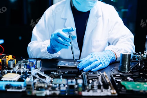 Preview: Closeup of expert soldering a green PCB board using precision tools. Ideal for electronics,