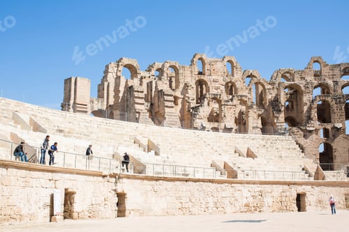 Preview: Tourists exploring ancient amphitheatre ruins on a sunny day