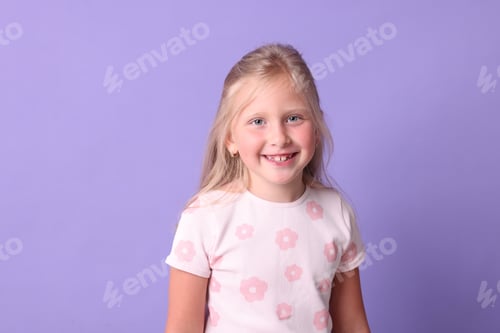 Preview: Smiling little girl on violet background. Positive emotion