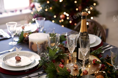 Preview: Christmas table setting with glasses and a bottle of champagne