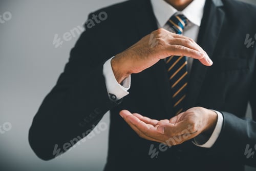 Preview: Man in suit with open palms, offering or protecting something. Gray background.
