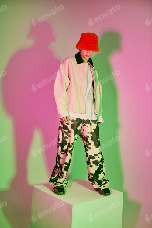 Preview: Young man showcases modern fashion with striking colors and bold patterns in a creative setting