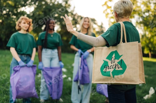 Preview: Volunteer waving to other volunteers while picking up trash