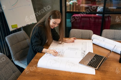 Preview: Pleased female architect analyzing rolled-out technical drawing