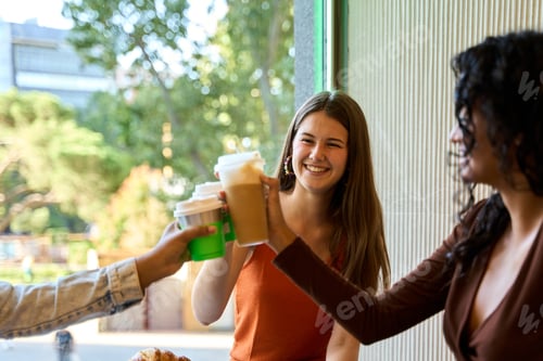 Preview: Happy young women toasting with coffee in cafe