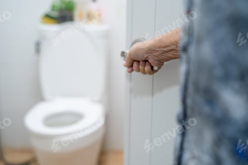 Preview: Asian senior elderly old lady woman patient open toilet bathroom by hand in nursing hospital