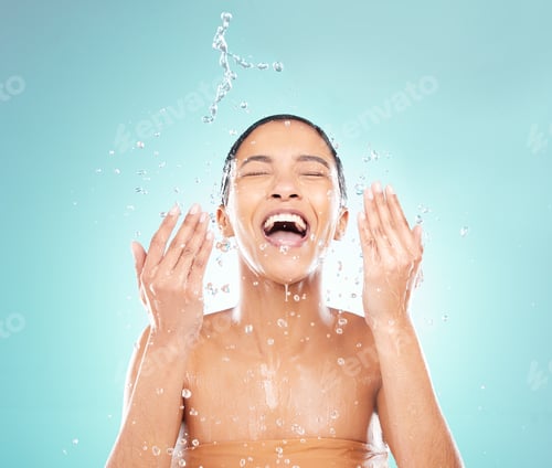 Preview: Shot of a young woman doing her daily skincare routine against a blue background
