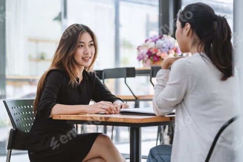 Preview: Image of young Asian businesswoman sitting in the office listening to a discussion explaining their