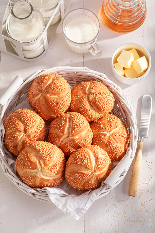Preview: Homemade Kaiser rolls with sesame seeds served with drink.