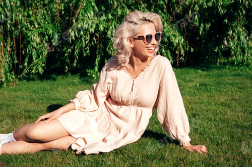 Preview: Young beautiful smiling blond woman posing outdoors