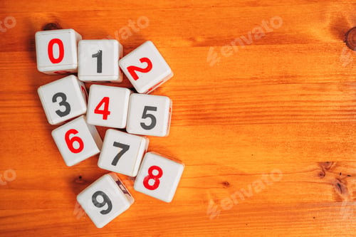 Preview: Learning numbers and mathematical calculation, top view of plastic cubes with numbers on wooden desk