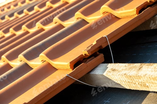 Preview: Closeup of metal montage anchor for installation of yellow ceramic roofing