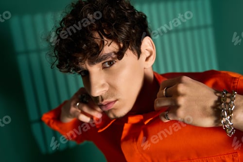 Preview: Stylish curly man showcasing trendy fashion in a vibrant studio setting