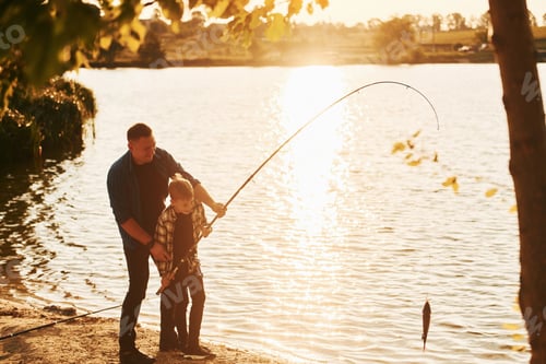 Preview: With catch. Father and son on fishing together outdoors at summertime