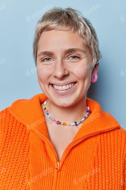 Preview: Close up shot of short haired young European woman smiles broadly has dimples on cheeks looks