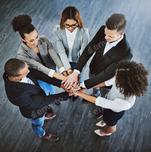 Preview: High angle shot of a group of businesspeople joining their hands together in a huddle