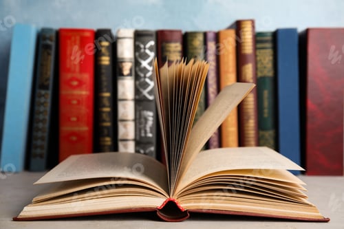 Preview: Open old book on light table in front of others