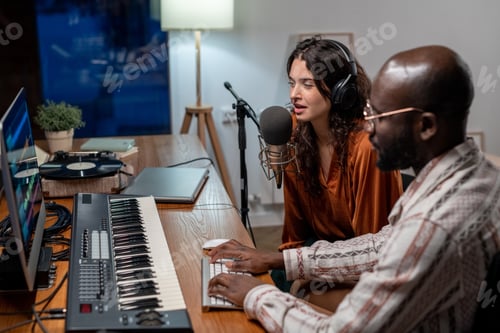 Visualização: Jovem mulher cantando no microfone enquanto negro gravando suas músicas