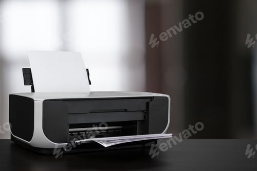 Preview: Compact laser printer on black desk against blurred background