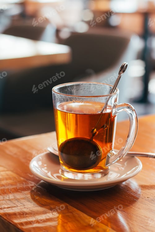 Preview: Glass Mug of hot tea at a cafe with blurred background. Natural light.