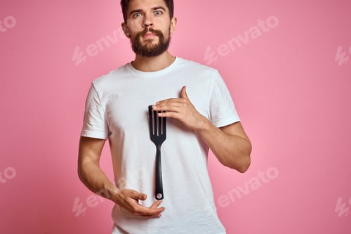 Preview: Man with spatula in hands kitchen accessories model emotions pink background cropped view Copy Space