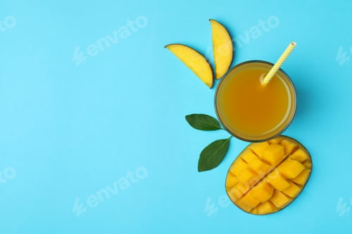 Vista previa: Ripe mango fruit and juice on blue background