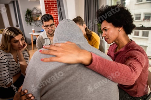 Preview: Diverse group of people sitting in circle in group therapy session.