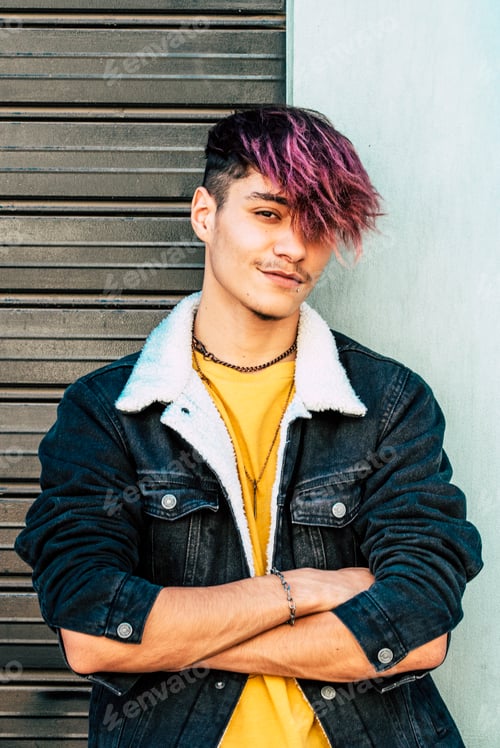 Preview: One young guy teenager standing against a wall and garage door looking on camera with trendy hair