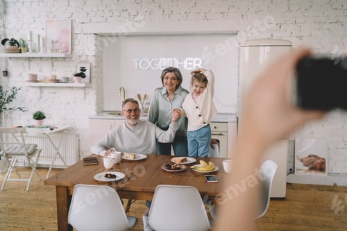 Preview: Anonymous taking photo on camera of happy family
